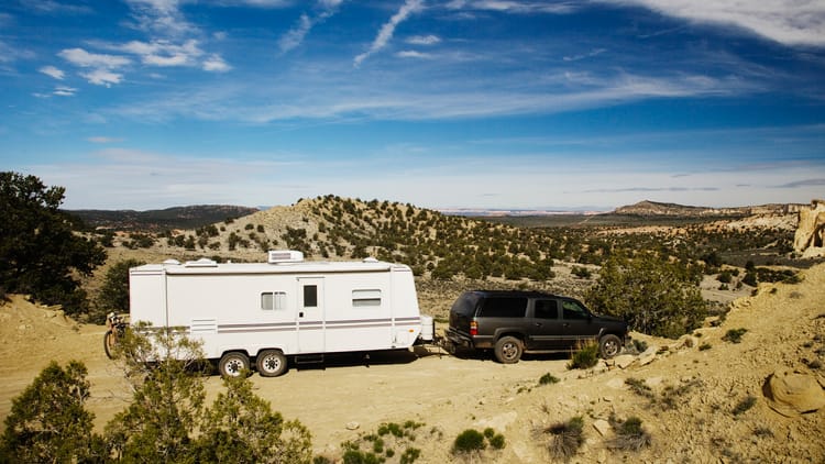 53788-car-pulling-trailer-in-desert-landscape-gra-2026-03-25-05-13-23-utc.
